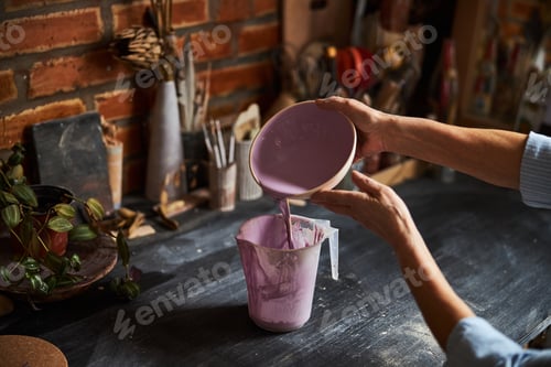 Preview: Female ceramic artist painting clay bowl in pottery workshop