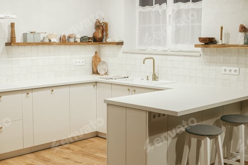 Preview: Modern kitchen interior. Stylish white kitchen cabinets with brass knobs, granite island