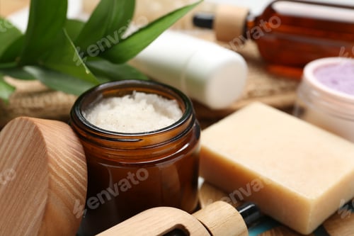 Preview: Different body care products and green leaves on table, closeup