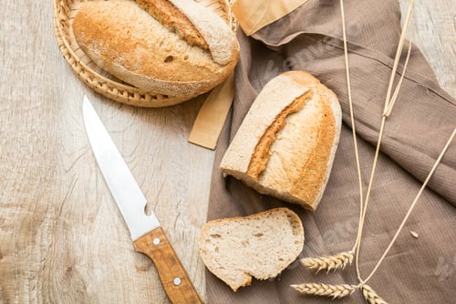 Preview: loaf of fresh bread slice of baguette with knife, baked pastry food closeup