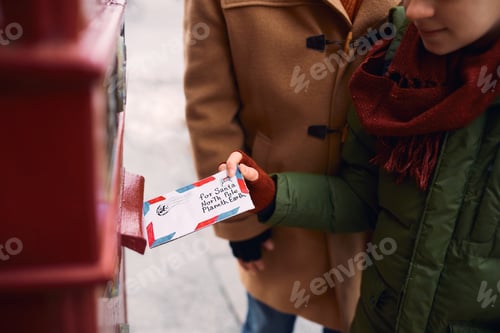 Preview: Close up of boy sending letter to Santa Claus.