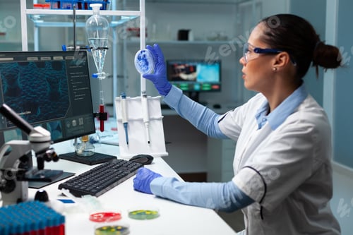 Preview: Biologist researcher woman looking at fungi colony using medical petri dish