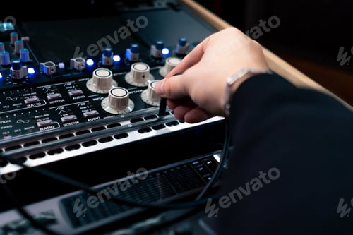 Preview: close up in dark recording studio the sound engineer works with the remote control and connects the
