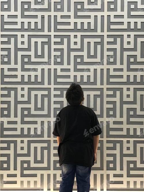 Child Standing Before Intricate Geometric Wall Design