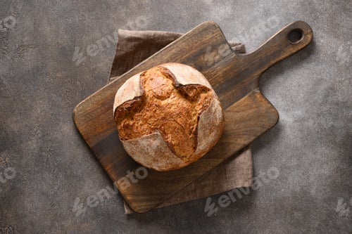 Preview: Loaf of freshly baked bread on brown background.