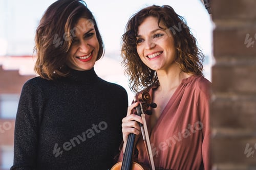 Preview: Young smiling women with violin on balcony