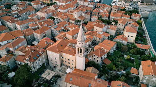 Preview: High bell tower of the Church of St. Ivan among the ancient houses of Budva. Montenegro. Drone