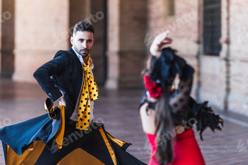Preview: Selective focus on a man with a cape dancing flamenco with a woman outdoors