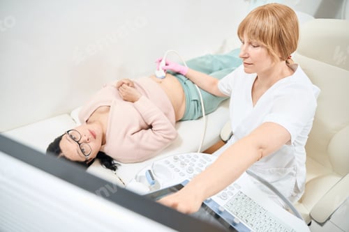 Preview: Female ultrasound specialist performing procedure, pointing at digital display