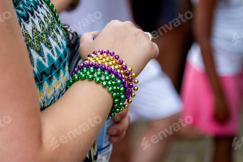 Preview: Necklaces adorn the arm of a festival goer