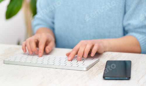 Preview: Female typing text on white keyboard on blue background. Freelance