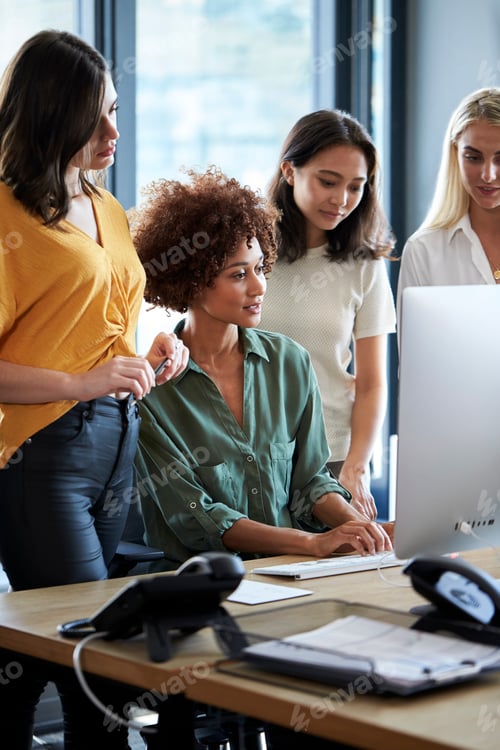 Preview: Four female creatives working around a computer monitor in an office, side view, vertical, close up