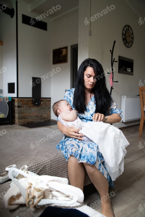 Preview: Caring Woman Holds Adorable Infant Indoors