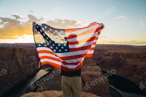 Preview: Anonymous male with USA flag near canyon
