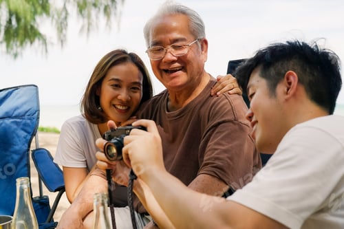 Preview: Happy Asian family with barbecue party at camping beach together