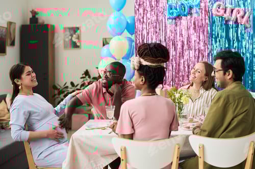 Preview: Happy young couple surrounded by diverse young adults celebrating gender reveal party