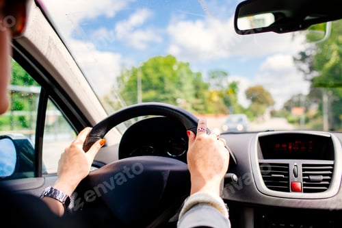 Preview: Cropped image of young woman driving car