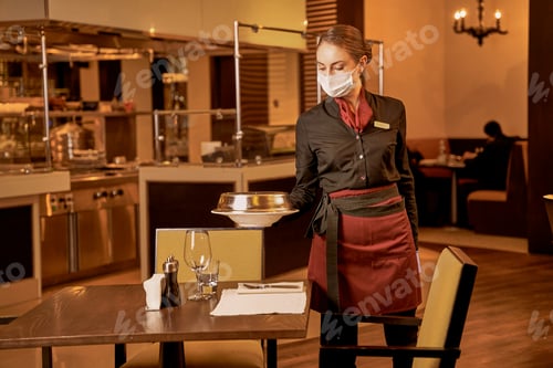 Preview: Waitress putting a restaurant meal on a prepared table