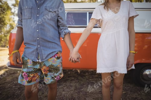 Preview: Couple holding hands against van
