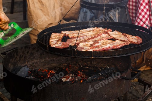Preview: Delicious meat ribs grilling on open grill