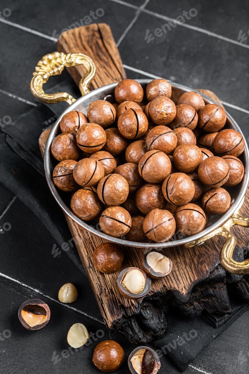 Preview: Macadamia nuts in a shell ready to eat. Black background. Top view