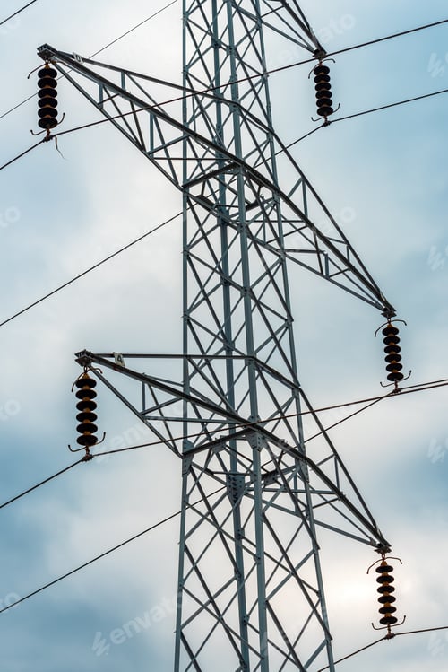 Preview: Energy crisis concept, electricity pylon with overhead powerline cables against dramatic sky