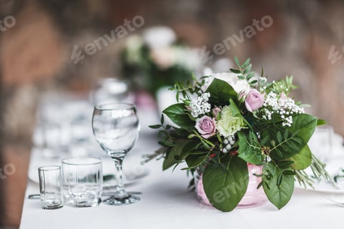 Preview: White wedding table decorated with green flowers arrangement, name cards, pink peony,