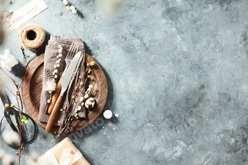 Preview: Easter table setting with spring flowers and cutlery on dark blue background top view flat lay