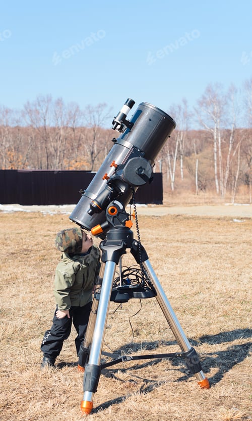 Preview: Child boy near big black telescope on a tripod at the observatory for observation of star and planet