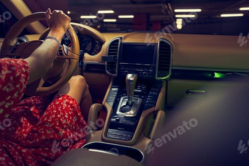 Preview: Woman sitting in car with control panel and gear shift