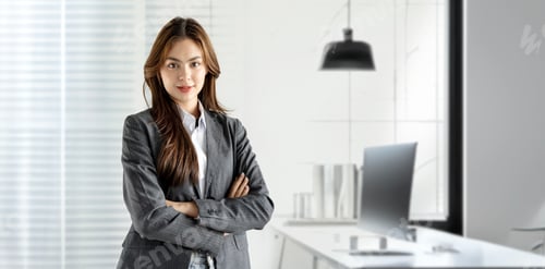 Preview: Beautiful businesswoman smiling at the camera, posing isolated over grey wall background.