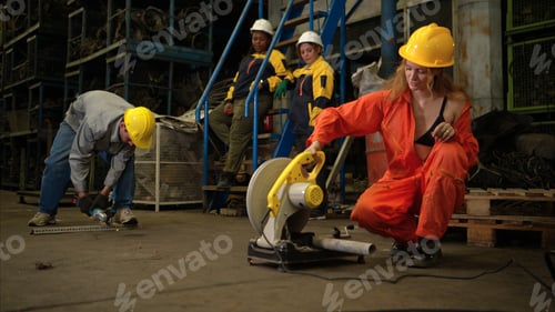 Preview: Team of factory workers wearing safety uniforms and helmets operating power tools