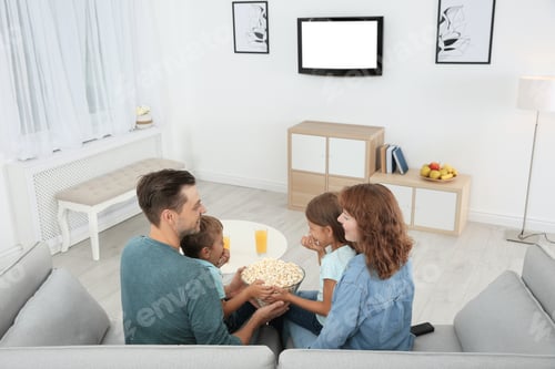 Preview: Family watching TV with popcorn in room