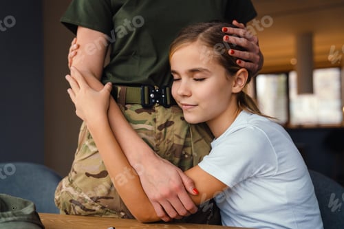 Preview: Beautiful military woman hugging with her smiling daughter