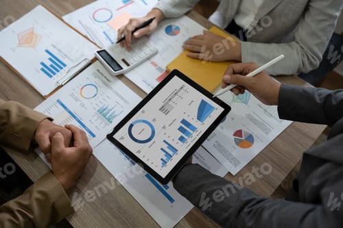 Preview: Top view of business colleagues in modern office analyzing income charts and graphs on digital