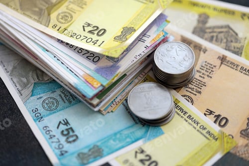 Preview: Indian rupee money bills and paisa coins pile on table. India coins on banknotes of INR currency