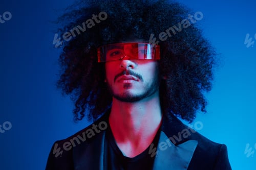 Preview: Fashion portrait of a man with curly hair on a blue background wearing red sunglasses, multinational