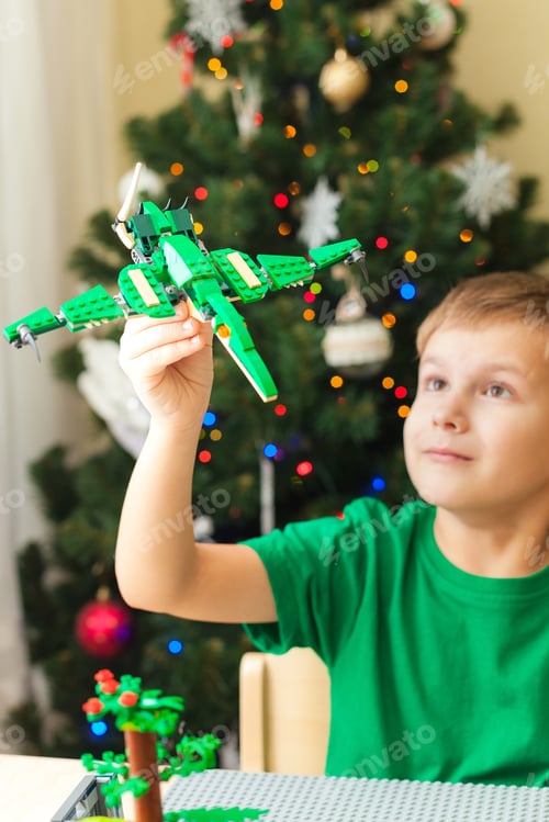 Preview: Young Boy with Toy Airplane by Christmas Tree