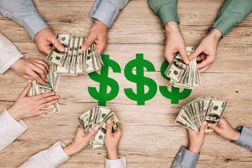 Preview: Top view of business partners counting dollar banknotes with dollar signs on wooden table