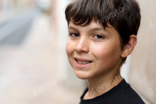 Preview: close up and portrait of teenager or boy smiling and looking at the camera
