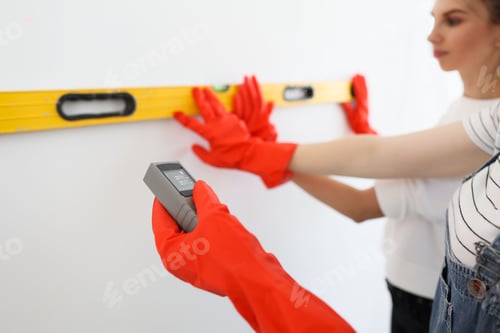 Preview: Laser rangefinder or laser tape measure in a female hand.