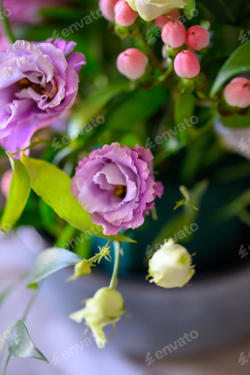 Preview: purple flowers in a green container and a white cloth and silver wire