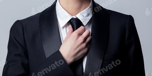Preview: business woman adjusts her black tie