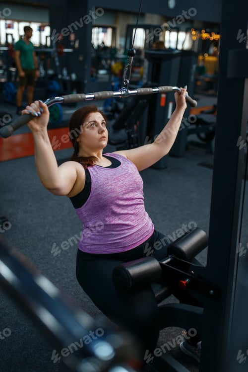 Preview: Overweight woman doing exercise in sport club