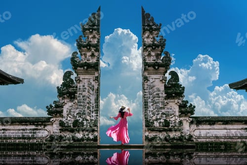 Preview: Female with a pink dress standing at Temple gates at Lempuyang Luhur temple in Bali