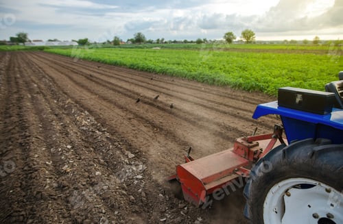 Preview: A tractor with a milling machine is cultivating a farm field.