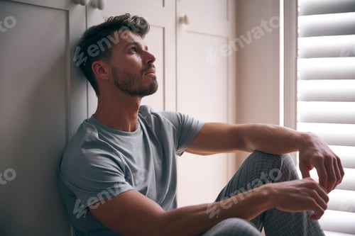 Preview: Close Up Of Depressed Man Suffering With Poor Mental Health Sitting On Floor At Home