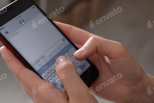 Preview: Woman sending message with text I Love You indoors, closeup