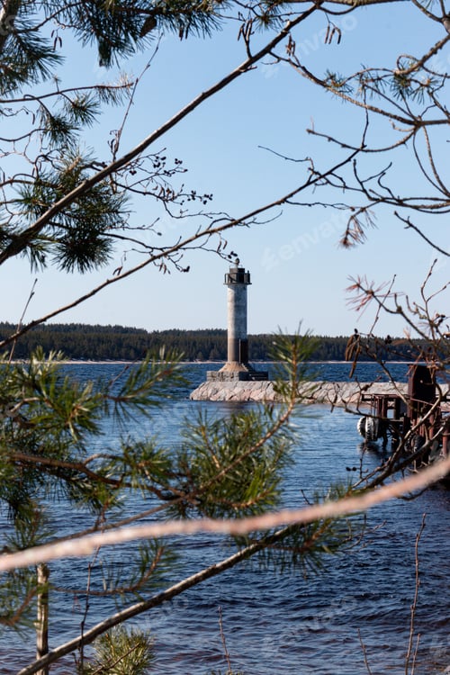 Preview: An abandoned lighthouse surrounded on all sides by blue water