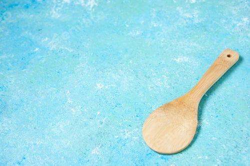 Preview: bottom view round wooden spoon on blue background with free space